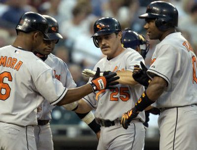 
Consistent veteran Rafael Palmeiro, center, is congratulated by his Baltimore Orioles teammates after a June 4 grand slam against the Detroit Tigers. 
 (Associated Press / The Spokesman-Review)