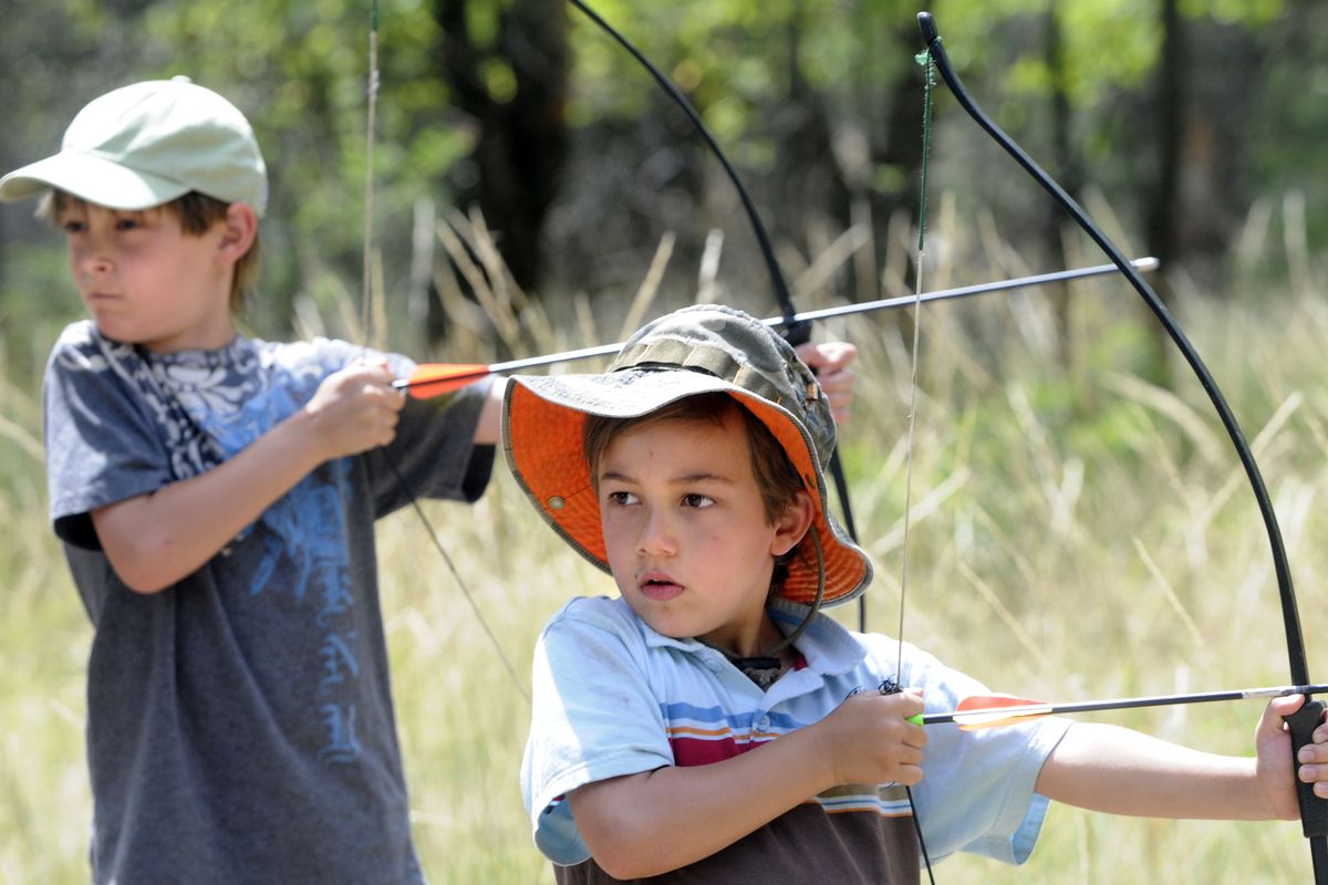 Brothers Grant Cleary, 7, left, and Drew Cleary, 5, wait for the command to fire at the archery station at Sekani Adventure Day. (Jesse Tinsley)