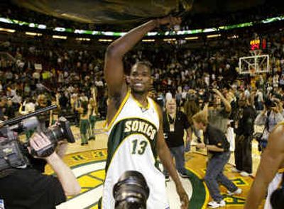 Seattle's Jerome James waves a plastic garbage bag over his head as he celebrates the Sonics' series-clinching win over Sacramento on Tuesday.
(Associated Press / The Spokesman-Review)