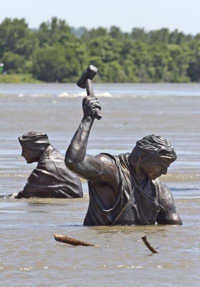 Statues of workers of various trades, part of the Monument for Labor by Matthew J. Placzek, stand in rising waters of the Missouri River, in Omaha, Neb., Wednesday. (Associated Press)