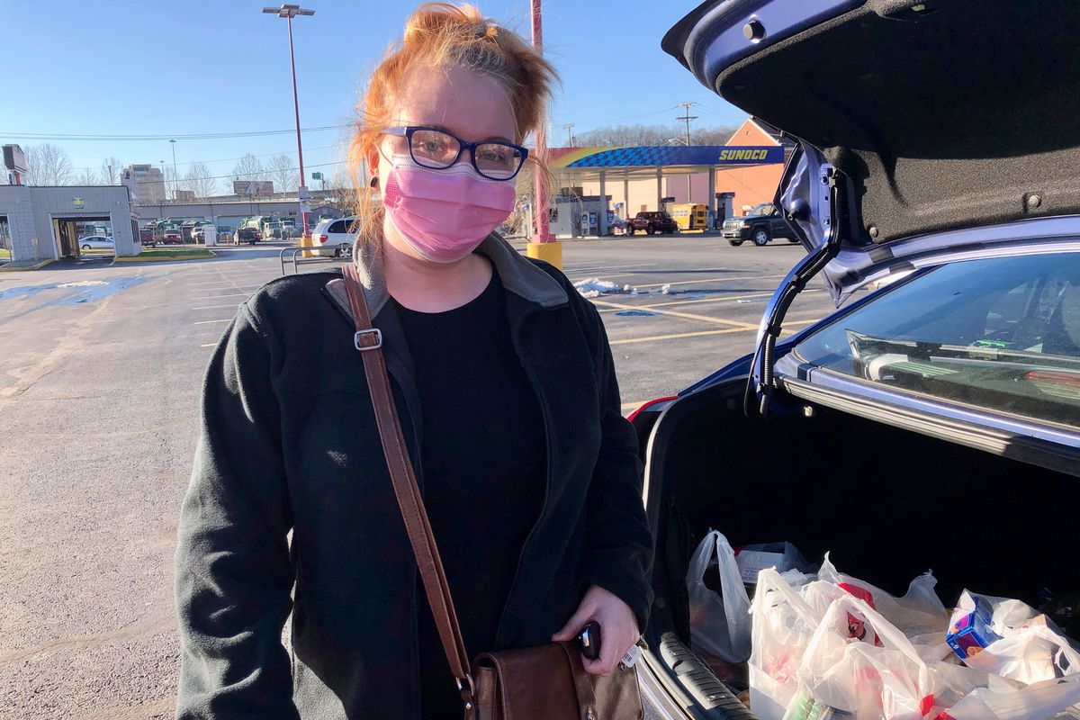Hairdresser Chelsea Woody stands outside her car at a grocery store Tuesday in Charleston, W.Va. For the first time in half a year, families are going without a monthly deposit from the federal child tax credit. Woody, a single mother, relied on the check to help raise her young son.  (John Raby)