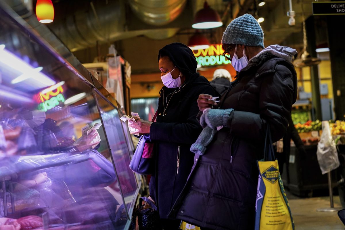 Customers wearing face masks to protect against the spread of the coronavirus shop at the Reading Terminal Market in Philadelphia on Wednesday. (Matt Rourke)