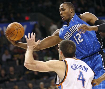 Dwight Howard, who had his first triple-double, grabs a rebound in front of Oklahoma City’s Nick Collison as Orlando won on road 109-92.  (Associated Press / The Spokesman-Review)