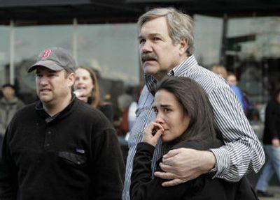 
Several people look on before being escorted inside at the scene of what police say was a murder-suicide  Monday morning. 
 (Associated Press / The Spokesman-Review)