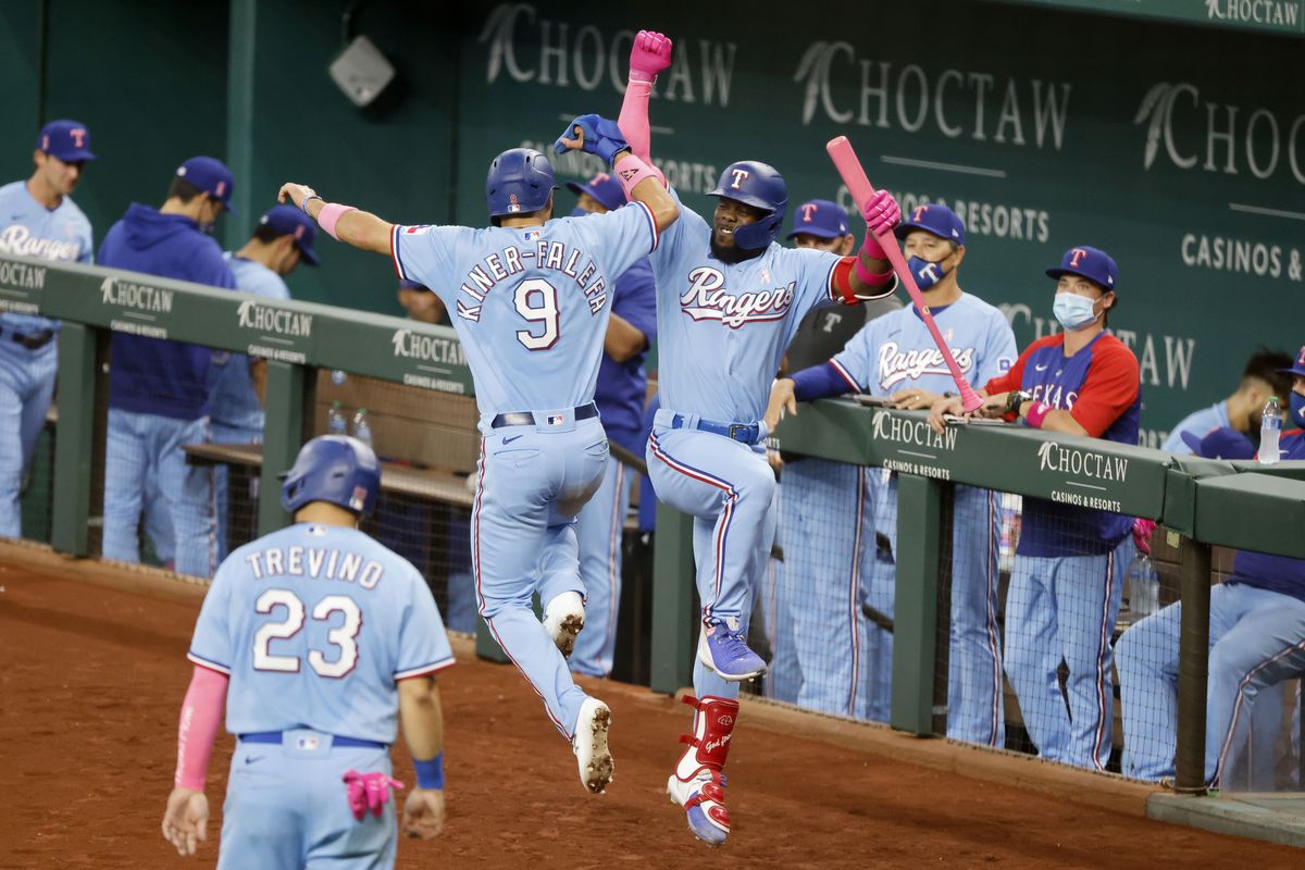Texas Rangers Isiah Kiner-Falefa (9) celebrates with Adolis Garcia, right, after scoring on a double by Willie Calhoun during the fifth inning of a baseball game against the Seattle Mariners, Sunday, May 9, 2021, in Arlington, Texas.  (Michael Ainsworth)