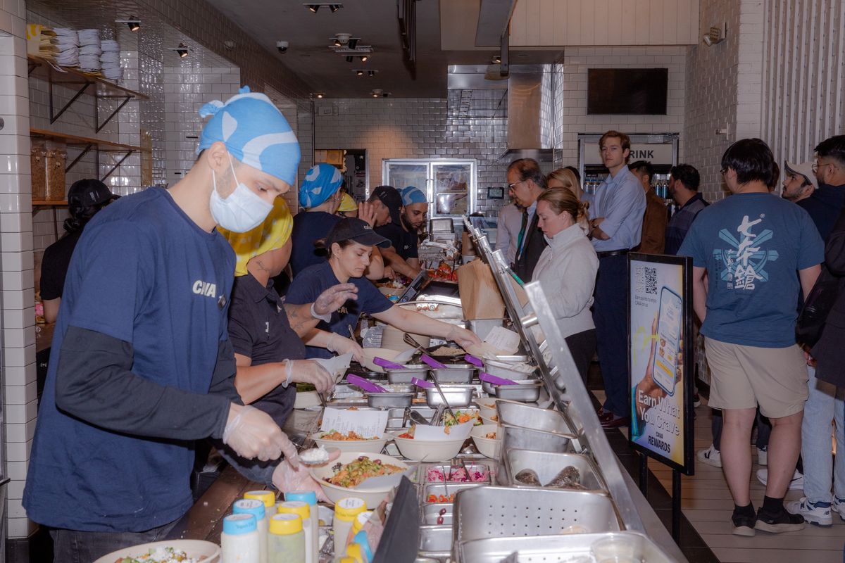 Employees prepare food at a Cava location in New York in May 2025. Sales and traffic at restaurant chains like Cava, Chipotle and Sweetgreen are falling, as customers grow tired of both salad bowls and their rising price tags.  (NATALIE KEYSSAR/New York Times)