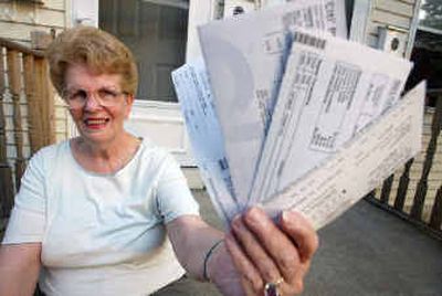 
Dale Gravelle shows off her credit card statements that she still owes money on after running up over $22,500 in debt at her home in Attleboro, Mass. Despite paying her mortgage and car payments on time, Gravelle managed to run her credit card debt up, but is now paying them off using a debt consolidation company. 
 (Associated Press / The Spokesman-Review)