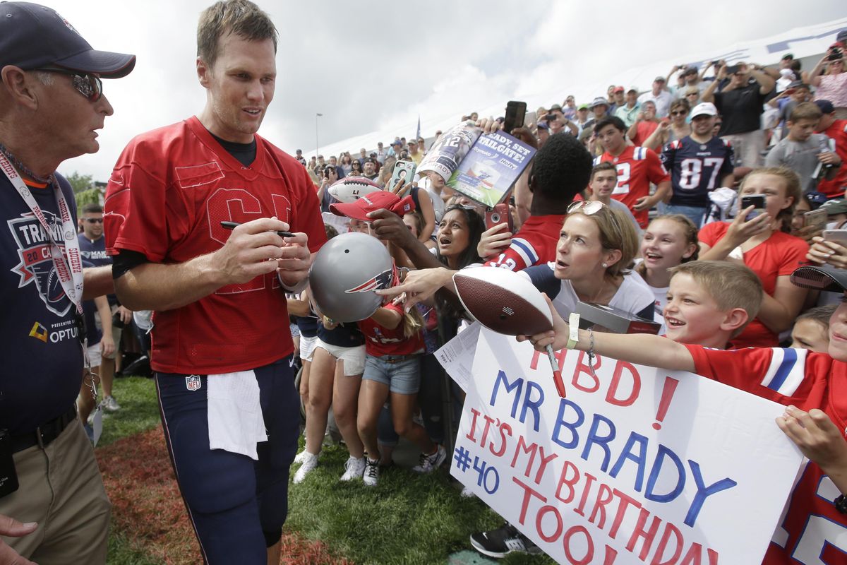 New England Patriots’ Tom Brady, center left, signs autographs for fans at NFL football training camp, Thursday, Aug. 3, 2017, in Foxborough, Mass. Brady turned 40-years-old Thursday. (Steven Senne / Associated Press)