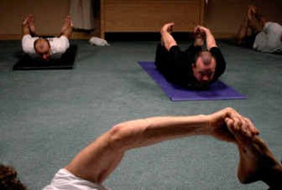 
Mike Tirrell, left, and Stan Wojcoski stretch during an extreme yoga class led by Martin Berson, foreground, at a Hartford health club. 
 (Hartford Courant / The Spokesman-Review)