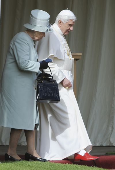 Britain’s Queen Elizabeth II and Pope Benedict XVI walk at the Palace of Holyroodhouse, in Edinburgh, Scotland, Thursday.  (Associated Press)