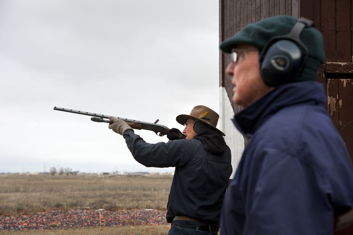 John Warning fires his pump-action shotgun with his friend Bill Brooks, right, launching skeets Wednesday at the Spokane Gun Club in Greenacres. (Dan Pelle)