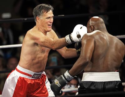 Mitt Romney lands a punch against Evander Holyfield at a charity fight Friday in Salt Lake City. (Associated Press)