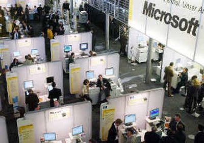 
People visit the stand of U.S. software company Microsoft at the Cebit 2004 computer fair in Hanover, northern Germanylast year. Microsoft has promised to produce a version of its flagship Windows operating system stripped of the program that plays music and video.
 (Associated Press / The Spokesman-Review)