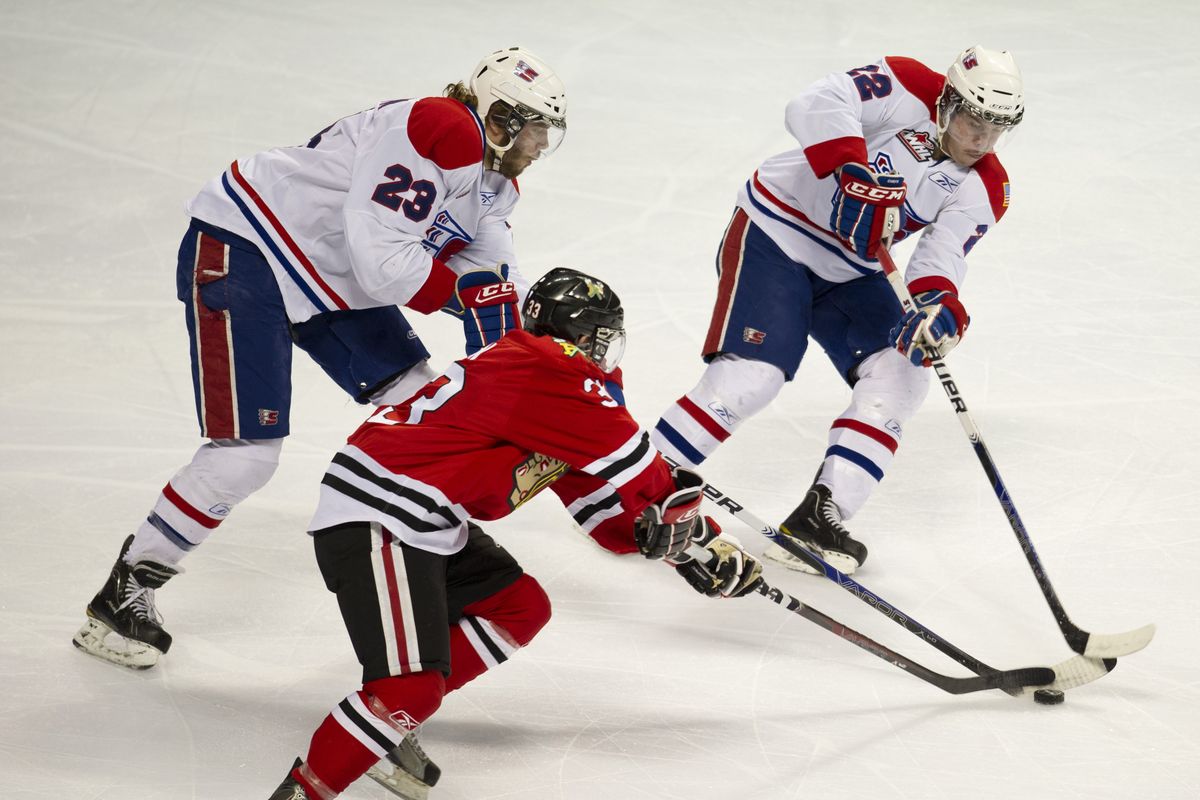 Spokane Chiefs Corbin Baldwin (23), Darren Kramer (22)  and Portland Winterhawks Nic Petan (33) chase the puck in the first period during game 3 of WHL Western Conference finals in Spokane, Wash., Wednesday, April 27, 2011. (Colin Mulvany / The Spokesman-Review)