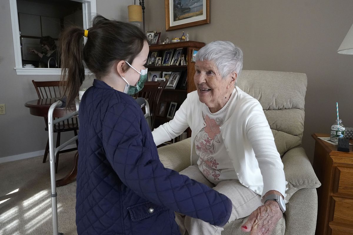 Eileen Quinn, 98, right, a resident at New Pond Village retirement community, in Walpole, Mass., greets her great-granddaughter Maeve Whitcomb, 6, of Norwood, Mass., left, Sunday, March 21, 2021, at the retirement community, in Walpole. Quinn said it was the first time she had been able to visit with her great-grandchildren in her apartment since the coronavirus pandemic began.  (Steven Senne)