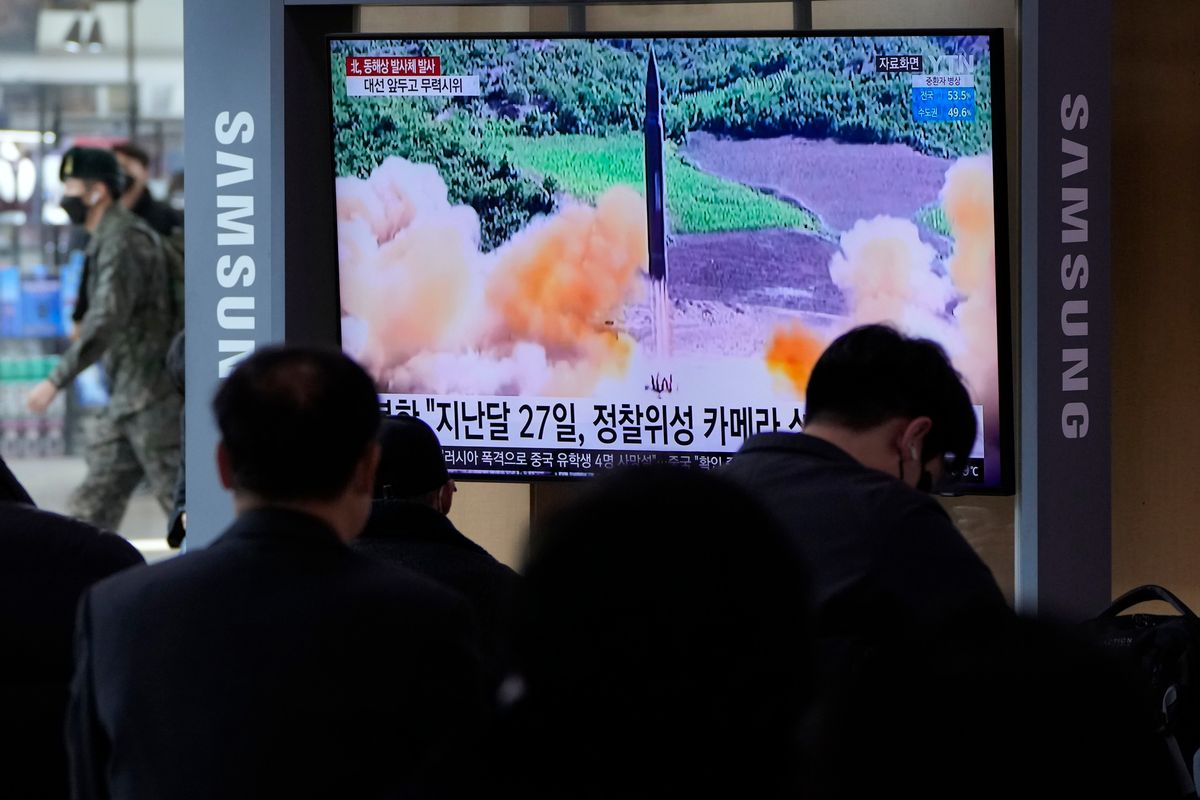 People watch a TV showing a file image of North Korea