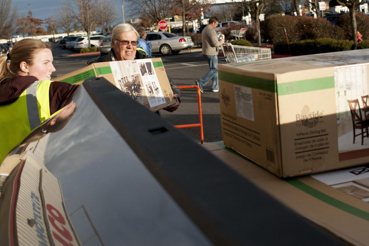 Jim Sadler, center, loads his truck up with furniture from Costco during the first quarter of Super Bowl LII on Sunday, Feb. 4, 2018, in Spokane, Wash. Sadler said he hoped to miss the regular Costco crowds and had set his TV to record the game. (Tyler Tjomsland / The Spokesman-Review)