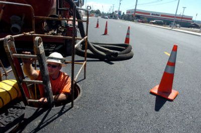 
Jake Cobb, of Henkels and McCoy, a utility contractor, comes  out of a manhole on Government Way near Haycraft on Tuesday. His crew was cleaning out utility spaces under the new pavement. 
 (Jesse Tinsley / The Spokesman-Review)