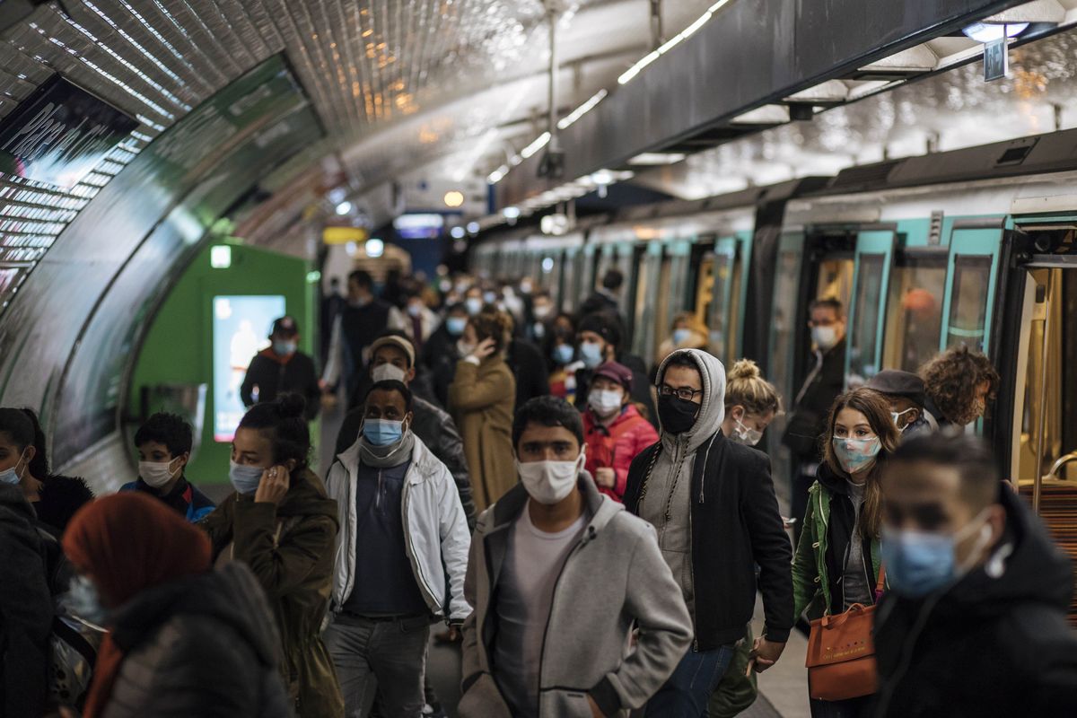 Commuters wearing face masks walk on the platform, of a Paris subway, Sunday Oct.25, 2020. A curfew intended to curb the spiraling spread of the coronavirus, has been imposed in many regions of France including Paris and its suburbs.  (Lewis Joly)