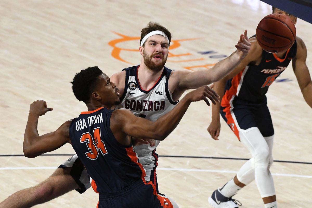 Gonzaga Bulldogs forward Drew Timme (2) loses control of the ball as Pepperdine Waves center Victor Ohia Obioha (34) and Pepperdine Waves forward Kessler Edwards (in back) defend during the first half of an NCAA college basketball game, Thurs., Jan. 14, 2021, in the McCarthey Athletic Center.  (Colin Mulvany/THE SPOKESMAN-REVIEW)