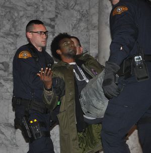 Protester is carried out of the Capitol Monday evening by Washington State troopers. (Jim Camden)