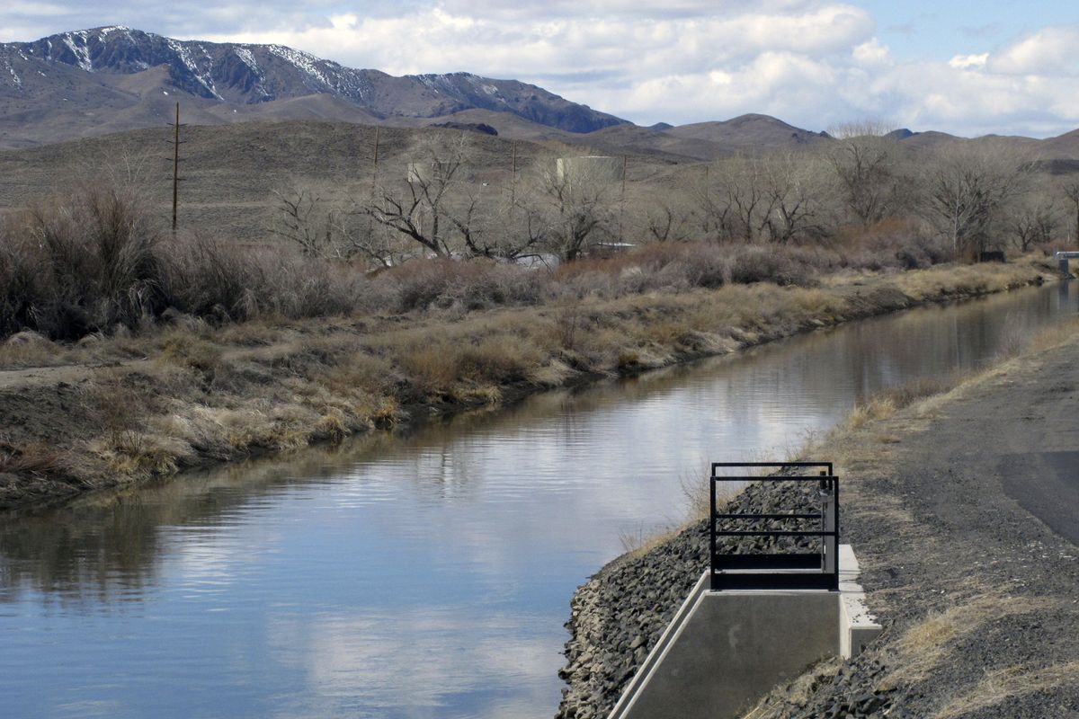 Water flows through an irrigation canal in Fernley, Nev. about 30 miles east of Reno Thursday, March 18, 2021. The town founded a century ago by pioneers lured to the West with the promise of free land and cheap water is suing the U.S. government over plans to renovate the earthen canal that burst and flooded nearly 600 homes in Fernley in 2008. Residents say plans to line parts of it with concrete will eliminate leakage they