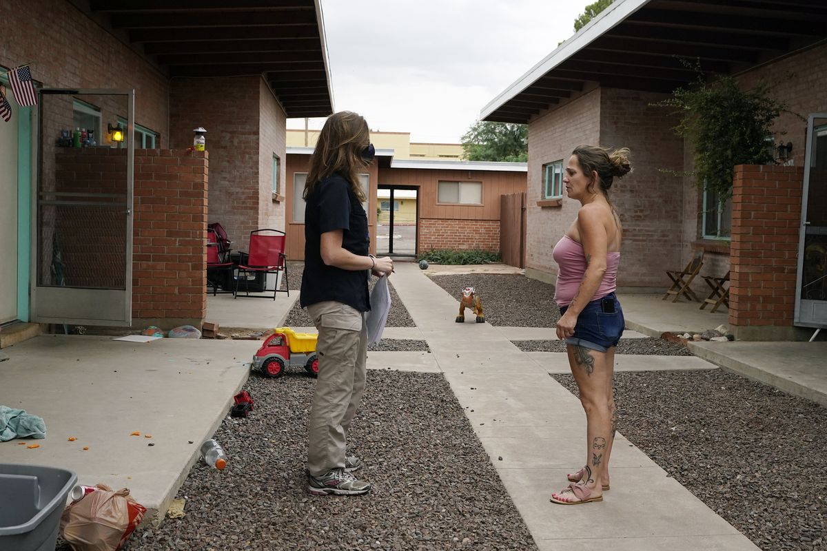 Pima County Constable Kristen Randall, left, speaks to a rental resident letting them know about their eviction notice Friday, Sept. 24, 2021, in Tucson, Ariz. Long delayed evictions are rolling out more than a month after the end of a federal moratorium that had protected tenants, including some who hadn't paid rent for many months during the coronavirus pandemic.  (Ross D. Franklin)