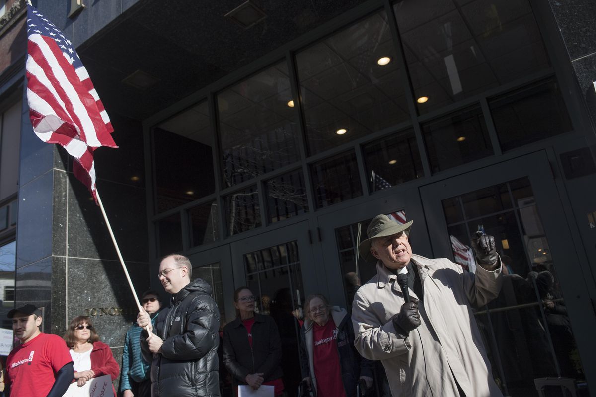 The Rev. George Taylor, visitation pastor at All Saints Lutheran Church, speaks in favor of the Affordable Care Act on Monday during a protest against the repeal of the law. The audience was about 100 people  in front of the Peyton building, where Rep. Cathy McMorris Rodgers has her Spokane office. (Jesse Tinsley / The Spokesman-Review)