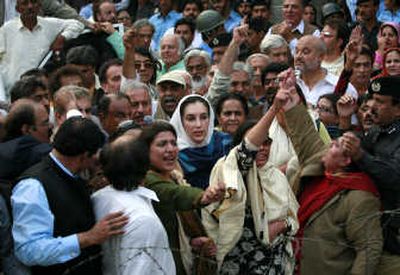 
Benazir Bhutto, center, and her supporters try to push their way through a police barricade outside her home in  Pakistan on  Friday. Associated Press
 (Associated Press / The Spokesman-Review)