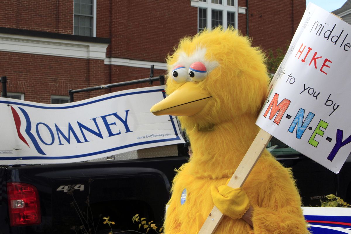 A person dressed as Big Bird holds a sign outside Republican presidential candidate, former Massachusetts Gov. Mitt Romney