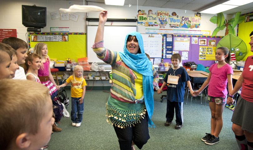 Opportunity Elementary School fourth-grade teacher Laurie Spence and students dance the Dabke, a traditional Lebanese dance, during International Day on Wednesday in Spokane Valley. The five-step dance is often performed at weddings. (Dan Pelle)