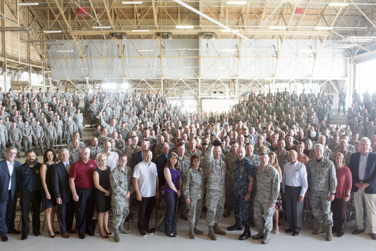 Col. Ryan Samuelson, center, holds up the silver Omaha Trophy, awarded for the second year in a row to Fairchild Air Force Base, alongside Vice Adm. Charles “Chas” Richard, to right of Samuelson,  and hundreds of airmen, Friday, Sept. 1, 2017, at FAFB at a gathering to celebrate the second award of the trophy, which recognizes excellence. (Jesse Tinsley / The Spokesman-Review)