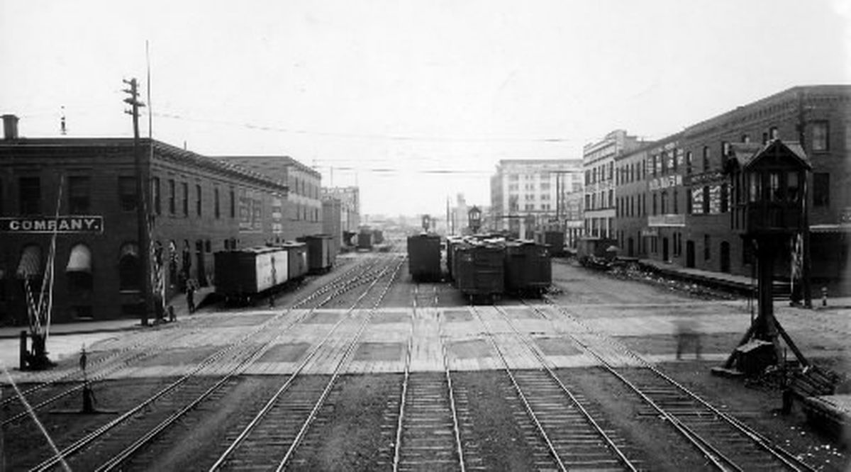 Beginning in 1881, the Northern Pacific railroad ran east and west through downtown Spokane, between First and Second streets, where the viaduct is now. Pictured here in about 1910, was the crossing at Post and Railroad, looking east. The first building on the right was Continental Distributing and is now Joel, Inc. The six-story building pictured further down on the right is the Holley Mason building.  (Photo Archive/The Spokesman-Review)