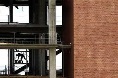 
A construction worker reaches for supplies Wednesday morning at WSU's Academic Center at Riverpoint in downtown Spokane. The cost of construction materials has increased dramatically since the project started. 
 (Brian Plonka / The Spokesman-Review)