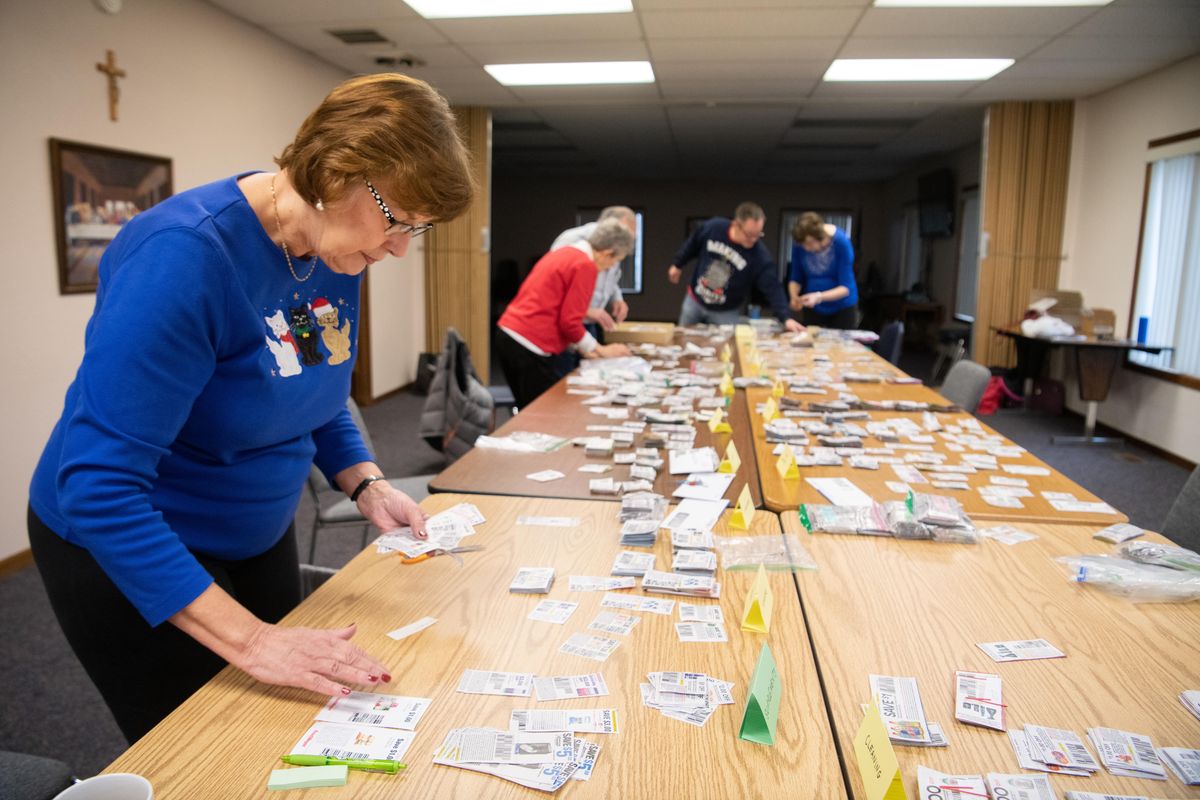 Kathy Miller sorts through the thousands of coupons that she and other volunteers clip every day to send to the troops Wednesday, Dec. 26, 2018, at St. Mary’s Catholic Church in Spokane Valley. Miller and other volunteers meet once a month to sort, count and double check expiration dates on the thousands of manufacturer coupons before mailing them to the Troopons headquarters from which theyre distributed to service members around the world for use in the PX. (Jesse Tinsley / The Spokesman-Review)