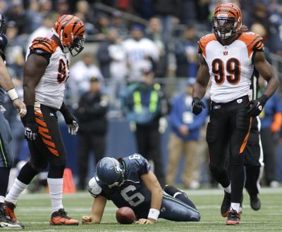 Seahawks quarterback Charlie Whitehurst lies on the field after being sacked during one of his three series. (Associated Press)