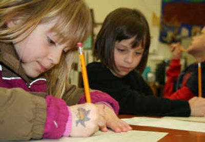 Seltice Elementary first-graders Kimmie Gilmore and Alexis Collins practice writing during Seltice's spring break school. 
 (Taryn Hecker / The Spokesman-Review)