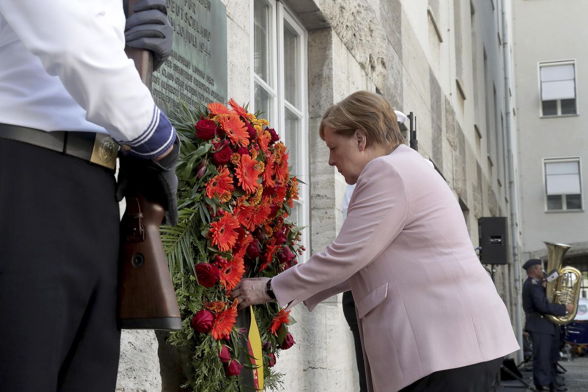 German Chancellor Angela Merkel adjusts a wreath during a memorial event at the Defence Ministry in Berlin, Germany, Saturday, July 20, 2019. On July 20, 2019 Germany marks the 75th anniversary of the failed attempt to kill Hitler in 1944. (Michael Sohn / AP)