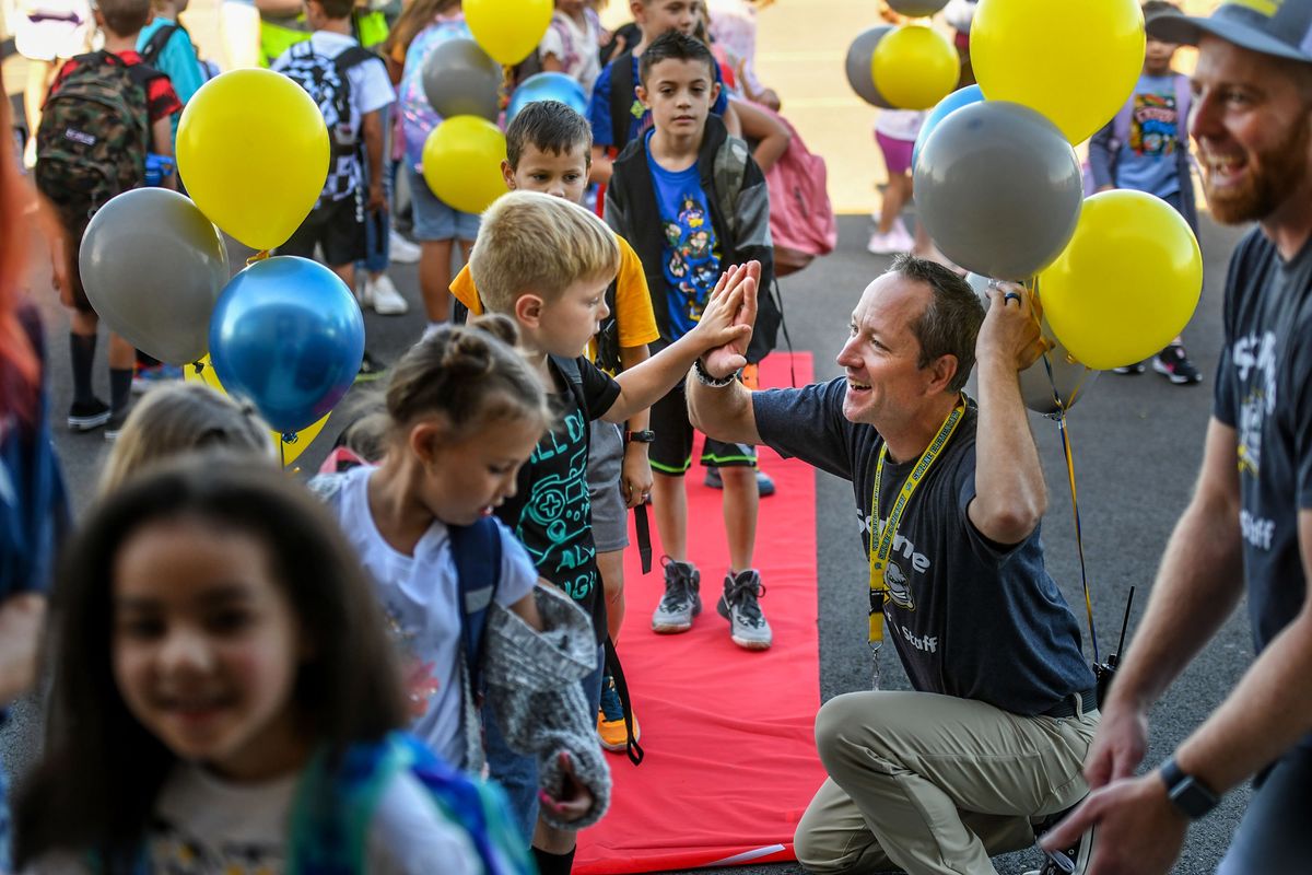 Skyline Elementary Principal Erik Olson high fives students during the red carpet walk for the first day of school in the Mead School District on Tuesday, August 30, 2022.  (Kathy Plonka/The Spokesman-Review)
