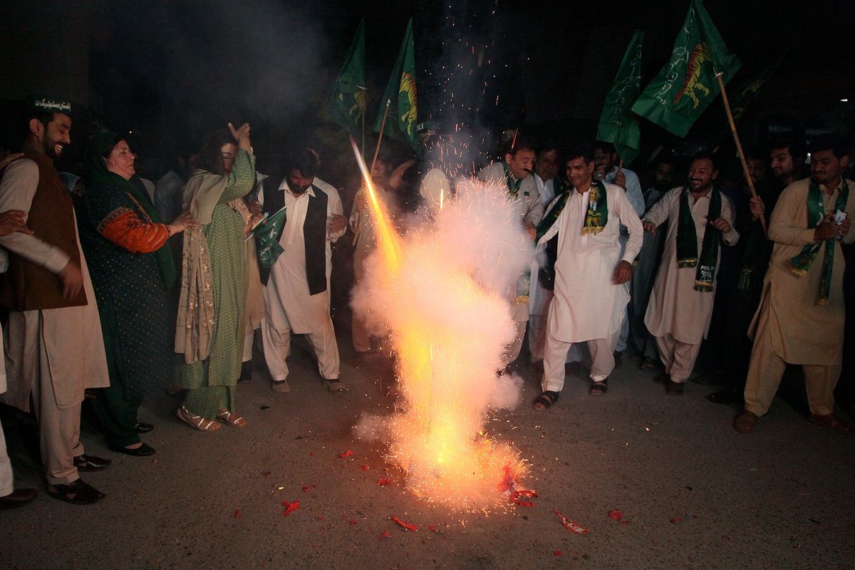Supporters of Pakistani opposition party hold firework to celebrate following the Supreme Court decision, in Peshawar, Pakistan, Thursday, April 7, 2022. Pakistan