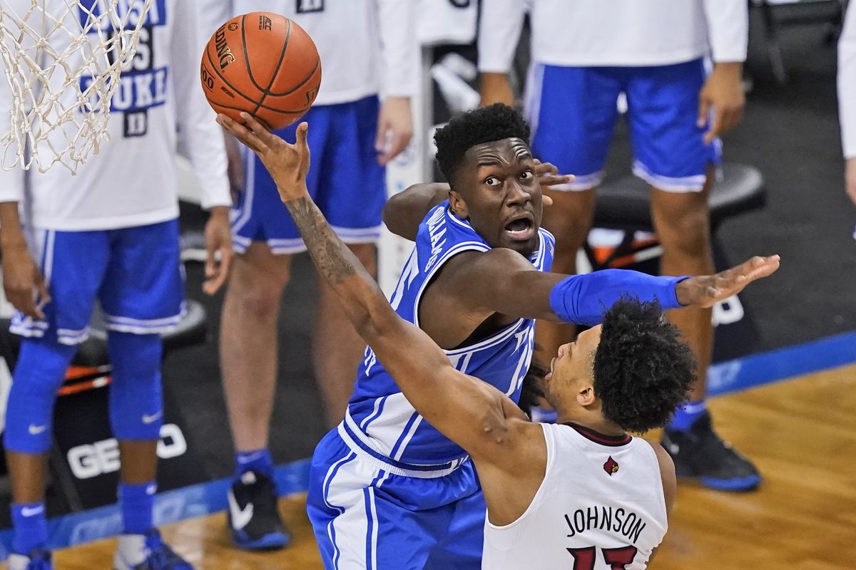 Duke center Mark Williams (15) tries to block the shot of Louisville guard David Johnson (13) during the first half of an NCAA college basketball game in the second round of the Atlantic Coast Conference tournament in Greensboro, N.C., Wednesday, March 10, 2021.  (Gerry Broome)