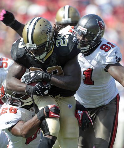 Tampa Bay’s Kregg Lumpkin, left, and Michael Spurlock chase down Chris Ivory in Sunday’s game, a 31-6 win for the Saints. (Associated Press)
