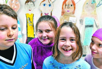 Hayden Meadows Elementary fourth-graders, from left, Curtis Cassano, Sami Koss, Sydney Croteau and Daisy Koler stand Wednesday in front of their self-portraits. The school is implementing the International Baccalaureate Primary Years Program into its curriculum. 
 (Kathy Plonka / The Spokesman-Review)