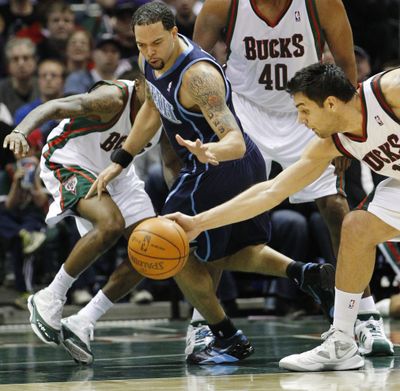 Milwaukee’s Carlos Delfino, right, steals the ball from Utah’s Deron Williams, center, during the first half of the Bucks’ win. (Associated Press)