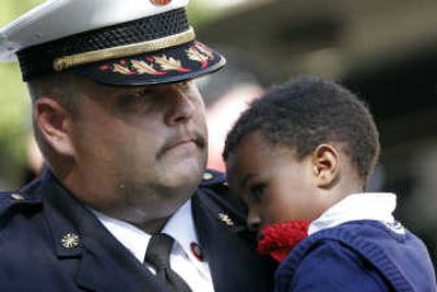 
Ruben Charity, the son of fallen Charleston, S.C., firefighter, Melvin Champaign, is carried into a memorial service Friday by Lancaster, S.C., Fire Chief Chris Nunnery.
 (Assoiciated Press / The Spokesman-Review)