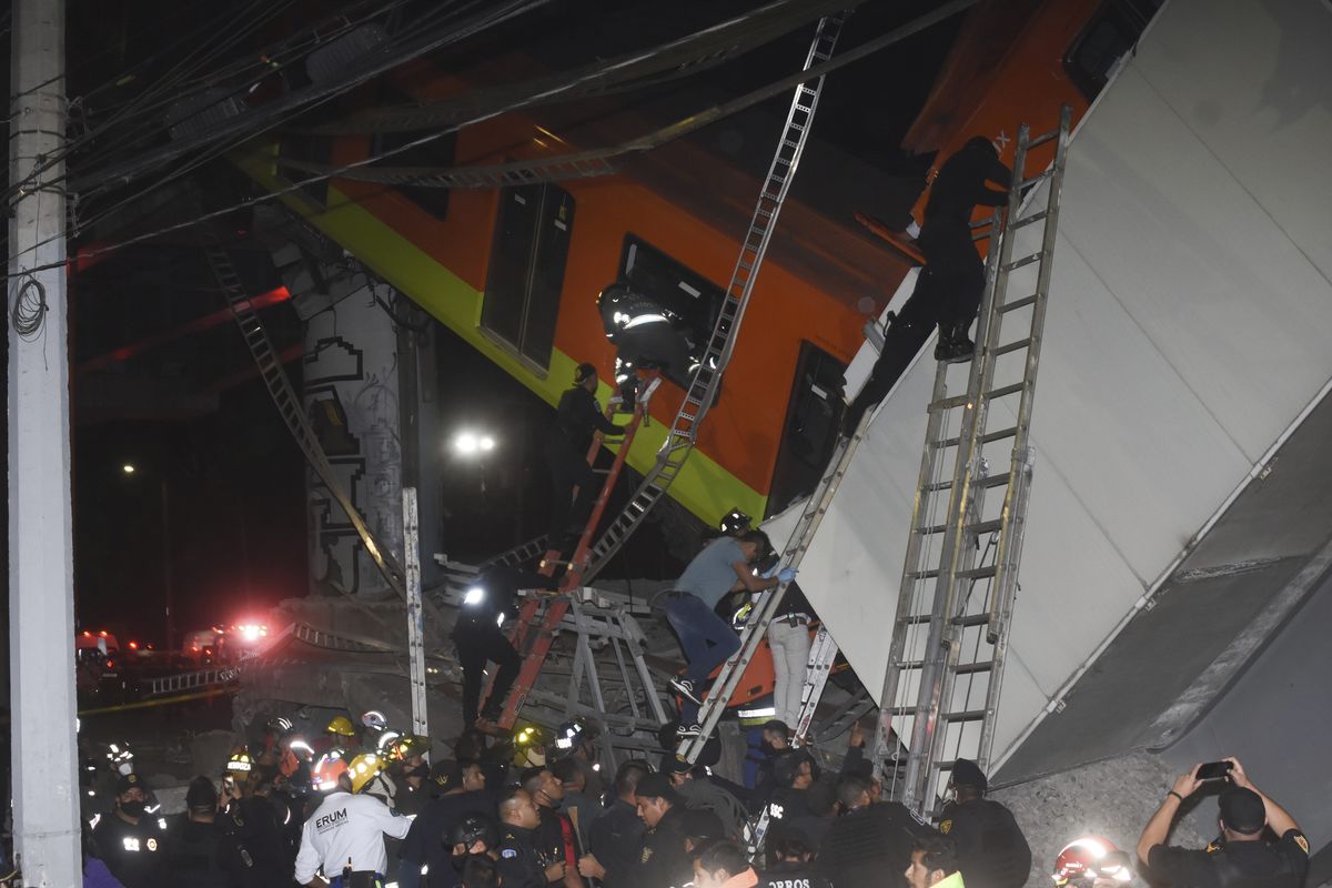 Mexico City fire fighters and rescue personnel work to recover victims from a subway accident after a section of Line 12 of the subway collapsed in Mexico City, Monday, May 3, 2021. The section passing over a road in southern Mexico City collapsed Monday night, dropping a subway train, trapping cars and causing at least 50 injuries and several dead, authorities said. (Jose Ruiz)
