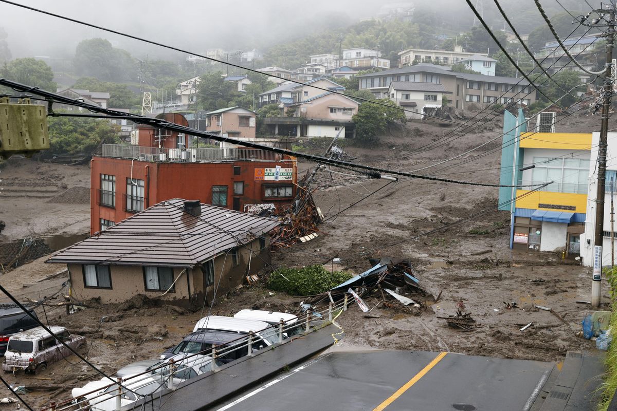 This photo shows buildings damaged by a mudslide at the Izusan district in Atami, west of Tokyo, Saturday, July 3, 2021, following heavy rains in the area. The mudslide carrying a deluge of black water and debris crashed into rows of houses in the town following heavy rains on Saturday, leaving multiple people missing, officials said.  (SUB)