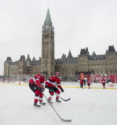 Ottawa Senators left wing Nick Paul, left, and defenseman Fredrik Claesson run a drill as they skate on the ice rink on Parliament Hill, Friday Dec. 15, 2017, in Ottawa. The Senators will play the Montreal Canadiens in the NHL 100 Classic regular season match outdoors on Saturday. (Adrian Wyld / Canadian Press via AP)