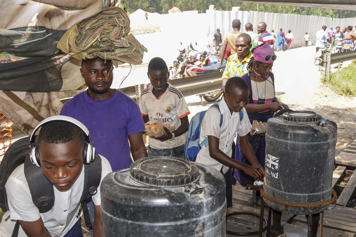 Women and schoolchildrencoming from Congo wash their hands with chlorinated water to prevent the spread of infection, at the Mpondwe border crossing with Congo, in western Uganda Friday, June 14, 2019. In Uganda, health workers had long prepared in case the Ebola virus got past the screening conducted at border posts with Congo and earlier this week it did, when a family exposed to Ebola while visiting Congo returned home on an unguarded footpath. (Ronald Kabuubi / Associated Press)