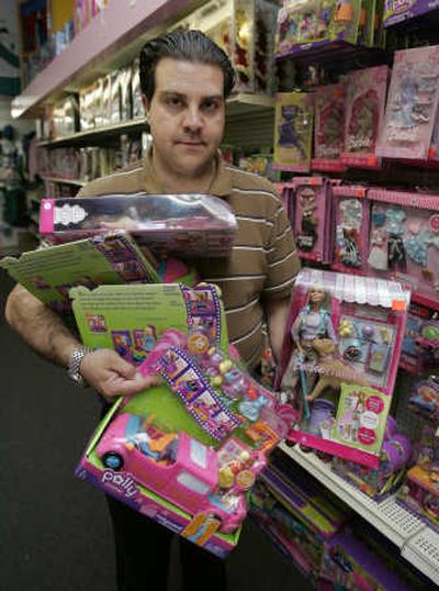 
Employee Keith Schumacher holds up the Polly Pocket Pollywood Limo-Scene, center, and the Barbie Tanner set, right, at Talbots Toyland in San Mateo, Calif. Schumacher removed the items after they appeared on the toy recall list. Associated Press
 (Associated Press / The Spokesman-Review)